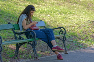 Girl watching her smarphone on a bench